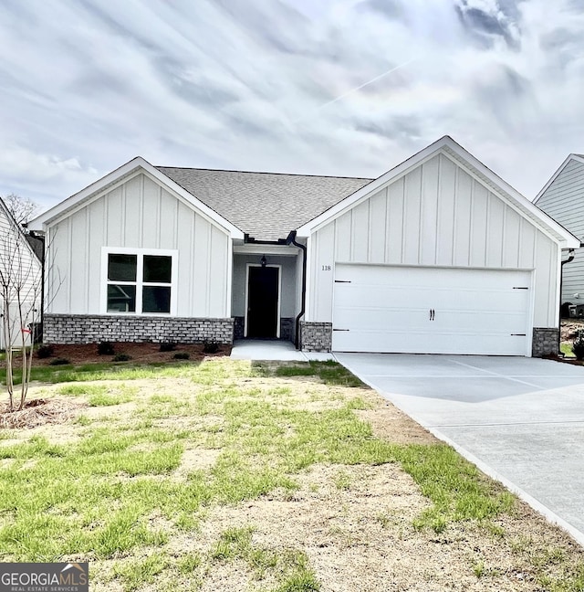 view of front of property with board and batten siding, a shingled roof, driveway, and a garage