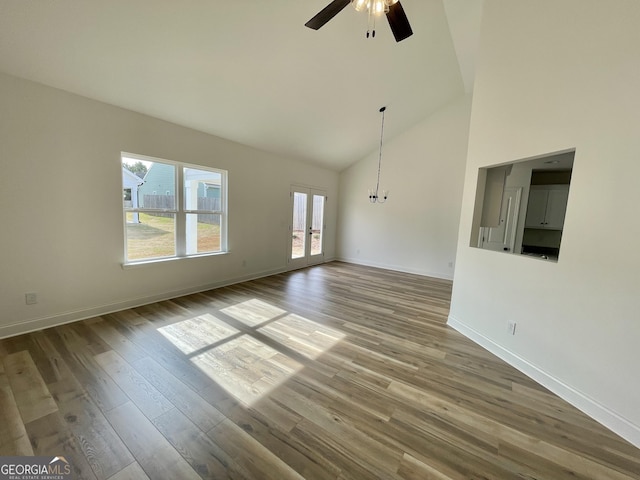 118 Charleston Ln, Milner, GA 30257 - unfurnished living room with a ceiling fan, high vaulted ceiling, wood finished floors, a chandelier, and french doors