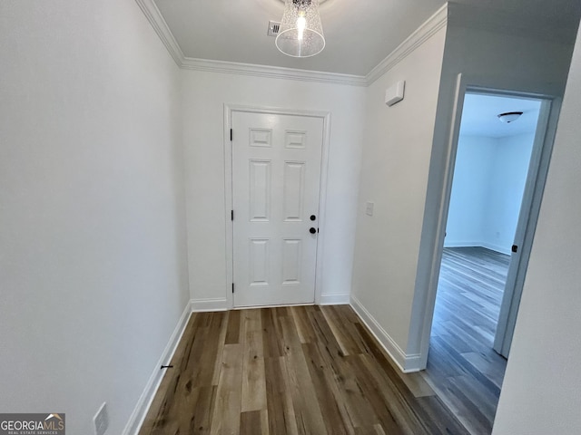 doorway to outside with ornamental molding, dark wood-style flooring, and baseboards