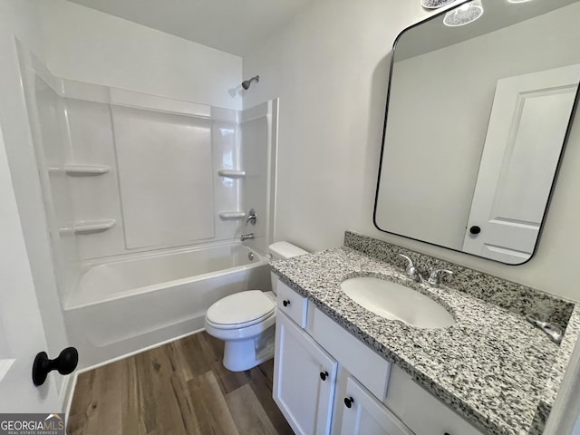 full bathroom featuring toilet, vanity, wood finished floors, and bathing tub / shower combination