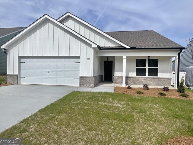 view of front of property with a porch, a front yard, and a garage