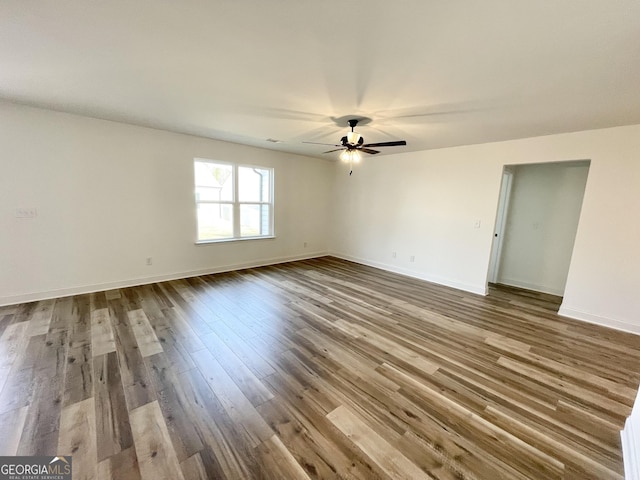 spare room featuring ceiling fan, baseboards, and wood finished floors