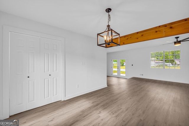 interior space featuring ceiling fan with notable chandelier and hardwood / wood-style floors