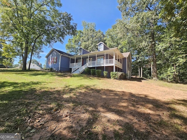 view of front of home with a porch, stairway, and a front lawn