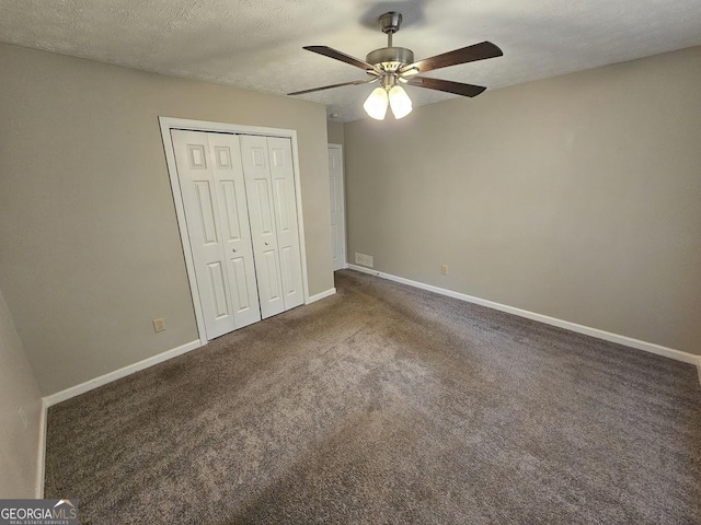 unfurnished bedroom with a ceiling fan, carpet, baseboards, a closet, and a textured ceiling