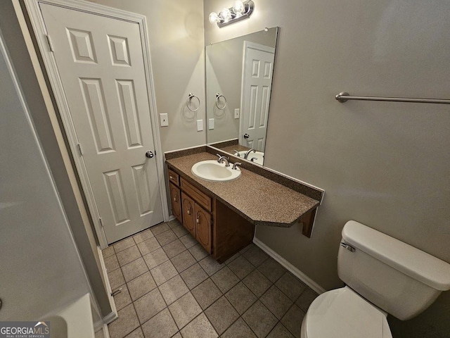 bathroom featuring vanity, tile patterned floors, toilet, and baseboards