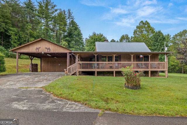 country-style home with a porch, a front lawn, and a carport