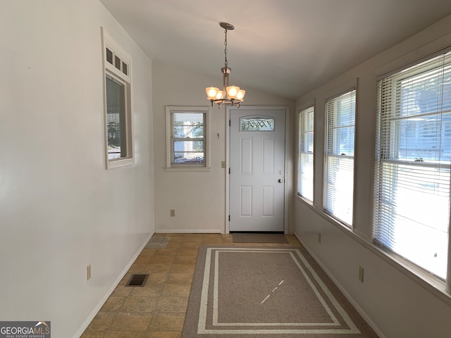 doorway to outside featuring lofted ceiling, plenty of natural light, and a chandelier