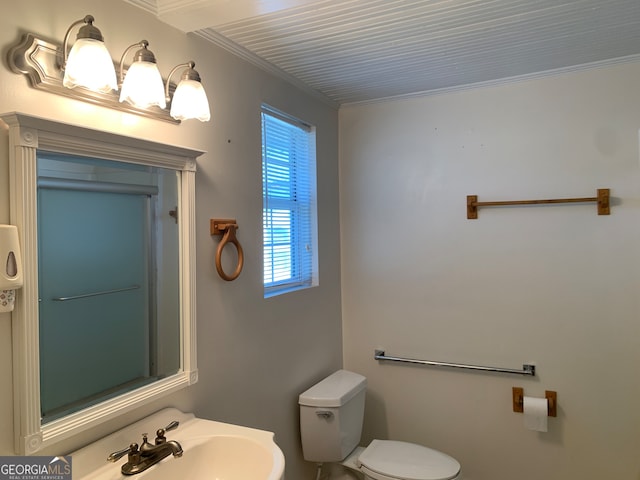 bathroom with ornamental molding, sink, and toilet