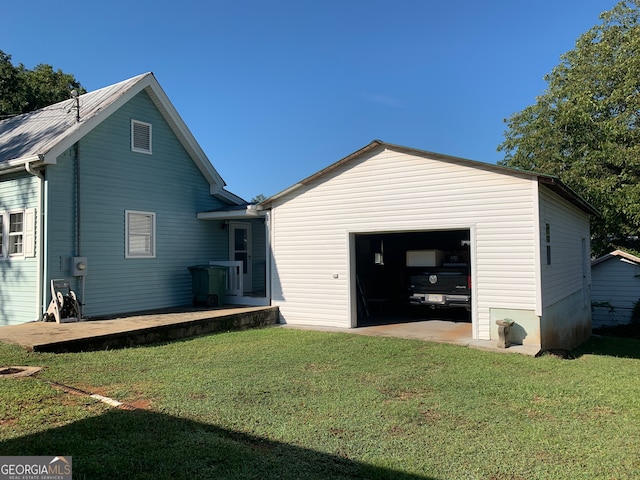 exterior space featuring a garage, an outbuilding, and a yard