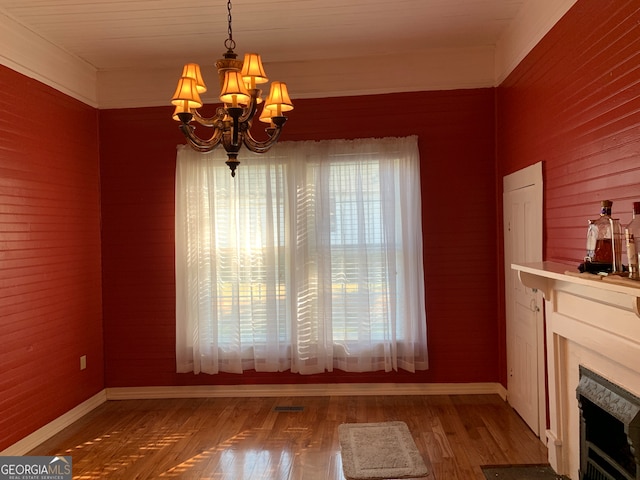 unfurnished dining area featuring hardwood / wood-style floors and an inviting chandelier