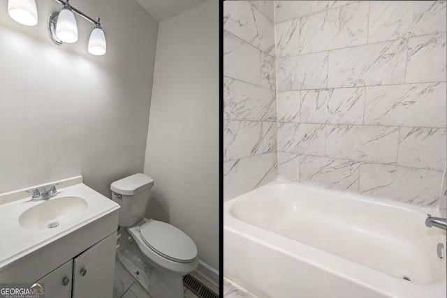 full bathroom featuring tiled shower / bath, vanity, and toilet