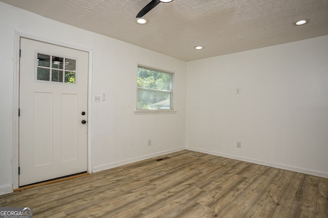 foyer entrance featuring wood-type flooring, a textured ceiling, and ceiling fan