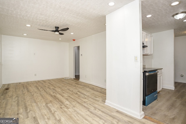 interior space with light wood-type flooring, ceiling fan, and a textured ceiling