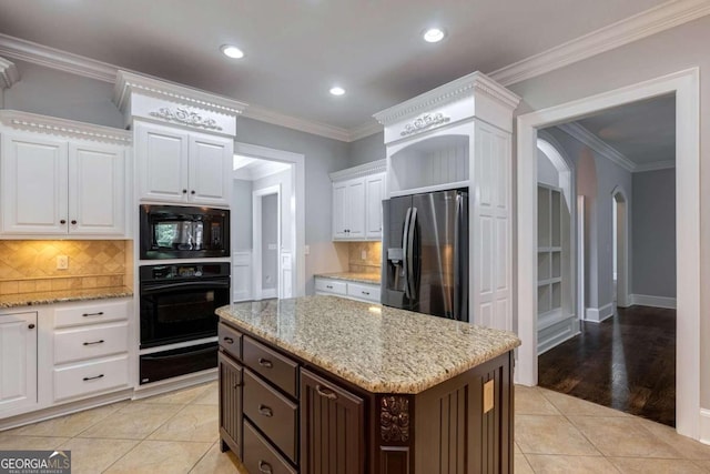 kitchen with light hardwood / wood-style flooring, white cabinets, black appliances, and crown molding