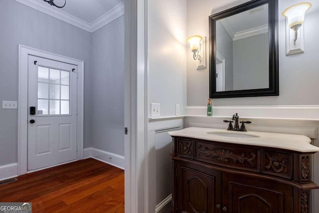 bathroom with wood-type flooring, vanity, and ornamental molding