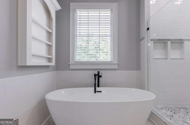 bathroom featuring separate shower and tub and tile walls