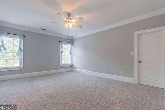 carpeted spare room with ceiling fan and crown molding