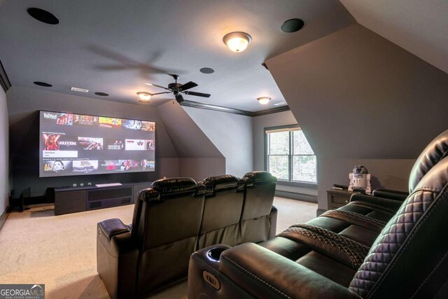 cinema with ceiling fan, light colored carpet, crown molding, and vaulted ceiling