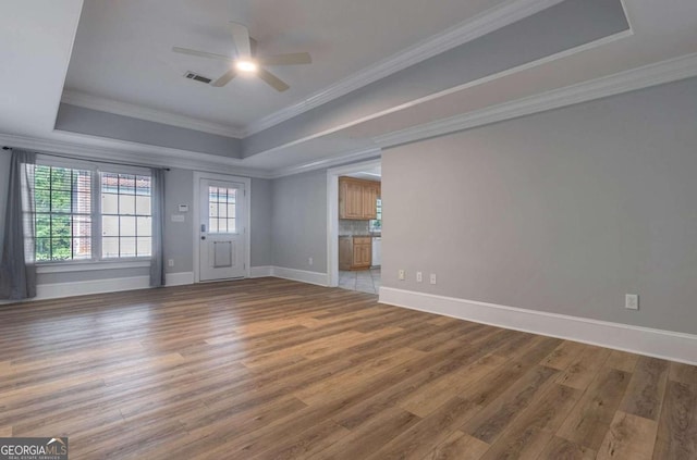 unfurnished living room featuring a tray ceiling, hardwood / wood-style floors, and ceiling fan