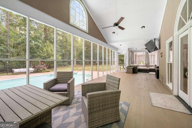 sunroom featuring lofted ceiling, a healthy amount of sunlight, and ceiling fan