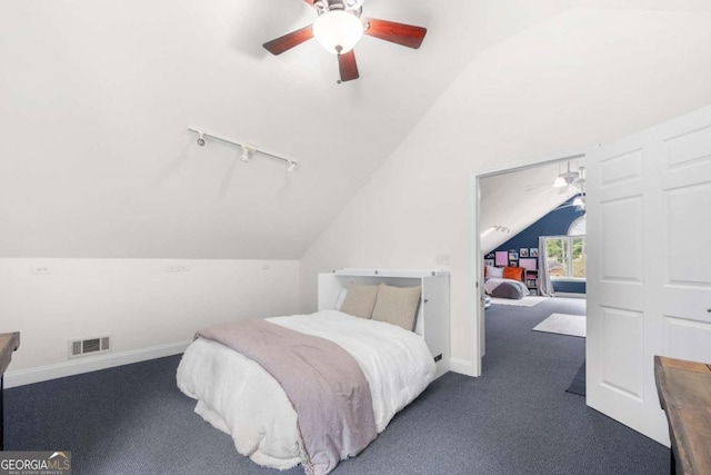 bedroom featuring dark carpet, vaulted ceiling, and ceiling fan