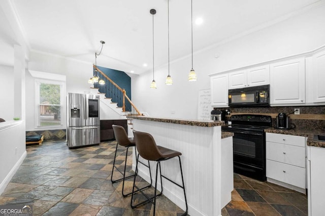 kitchen with decorative backsplash, white cabinets, a breakfast bar, ornamental molding, and black appliances