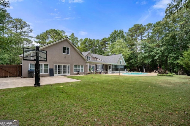 rear view of property featuring a patio area and a yard