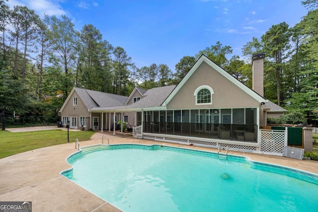 view of swimming pool with a patio and a sunroom