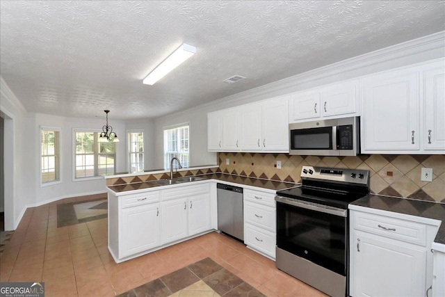 80 Stewart Hollow Ln, Covington, GA 30016 - kitchen featuring white cabinetry, a peninsula, a sink, and appliances with stainless steel finishes
