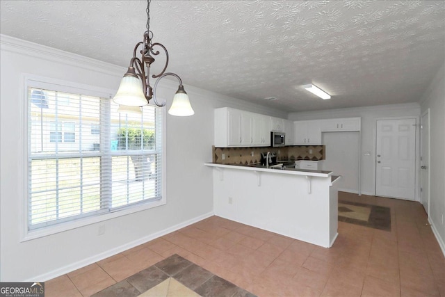 80 Stewart Hollow Ln, Covington, GA 30016 - kitchen featuring backsplash, a kitchen breakfast bar, a peninsula, stainless steel microwave, and white cabinets
