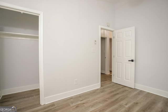 unfurnished bedroom featuring light wood-type flooring and a closet