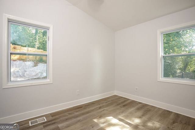 unfurnished room with vaulted ceiling and hardwood / wood-style floors