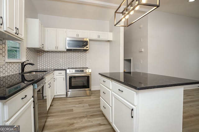 kitchen featuring light hardwood / wood-style floors, white cabinets, a kitchen island, stainless steel appliances, and sink