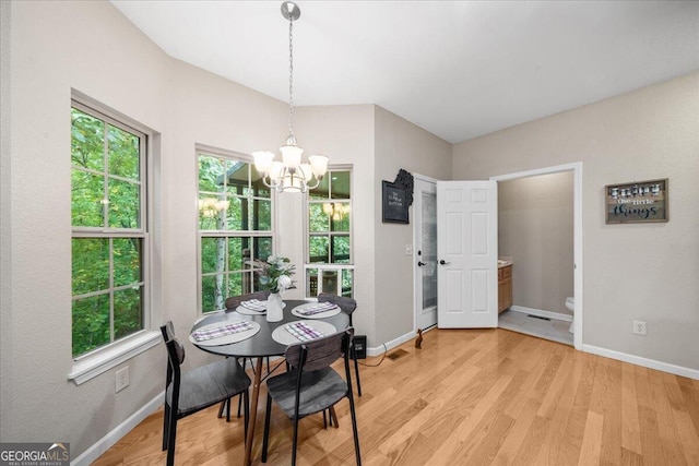 dining space featuring light wood-type flooring, a chandelier, and plenty of natural light