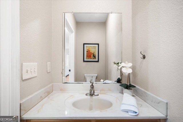 bathroom featuring vanity and toilet