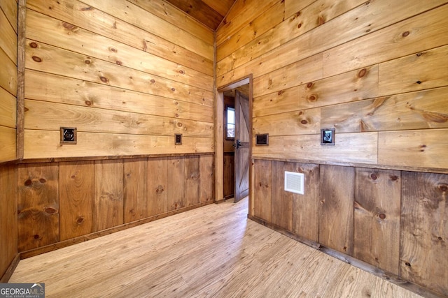 bonus room with wooden walls and light hardwood / wood-style flooring