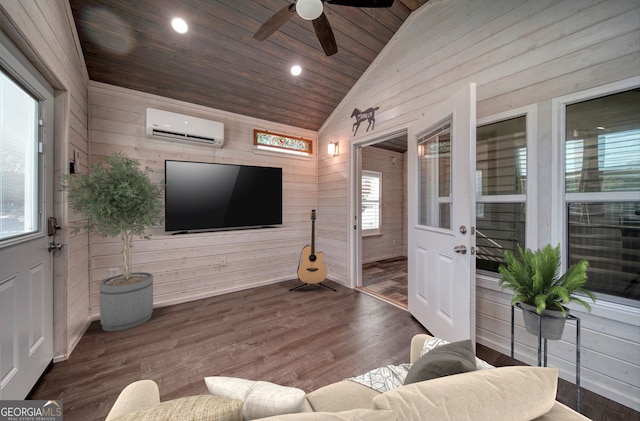 living room featuring ceiling fan, vaulted ceiling, an AC wall unit, and a healthy amount of sunlight