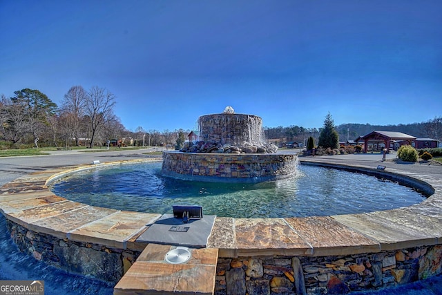 view of swimming pool with pool water feature