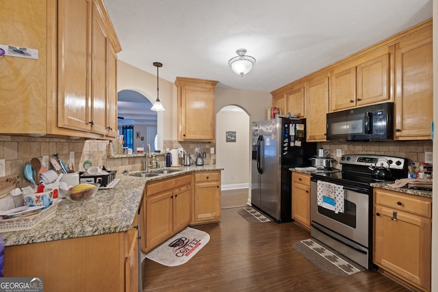 kitchen with sink, tasteful backsplash, decorative light fixtures, appliances with stainless steel finishes, and dark hardwood / wood-style flooring