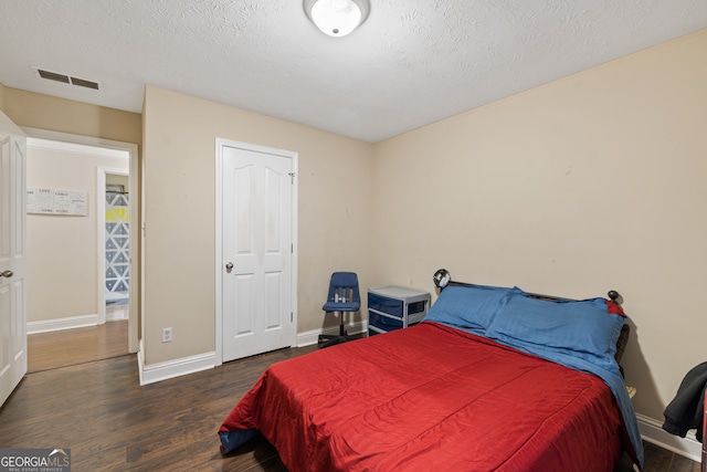 bedroom featuring a textured ceiling and dark wood-type flooring