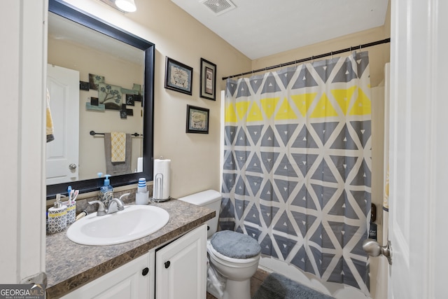 bathroom featuring curtained shower, vanity, and toilet