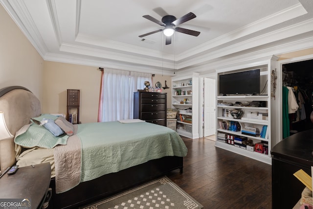 bedroom featuring a raised ceiling, crown molding, ceiling fan, and dark wood-type flooring