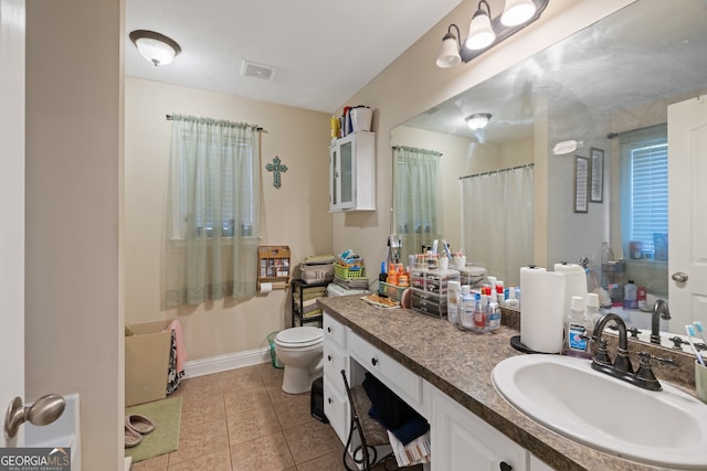 bathroom with vanity, tile patterned flooring, and toilet