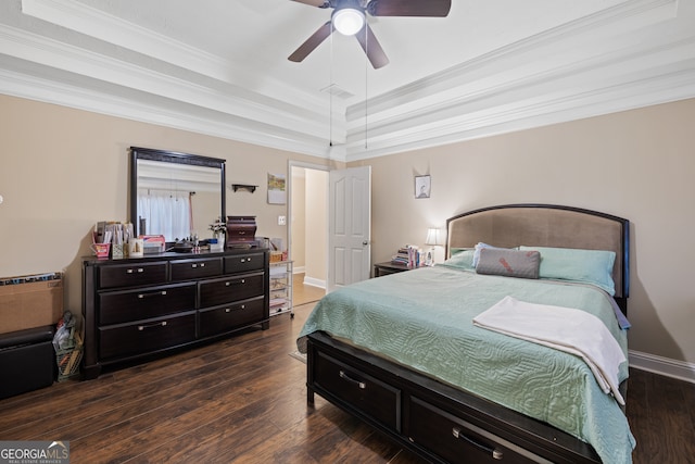 bedroom featuring ceiling fan, a tray ceiling, dark hardwood / wood-style floors, and ornamental molding