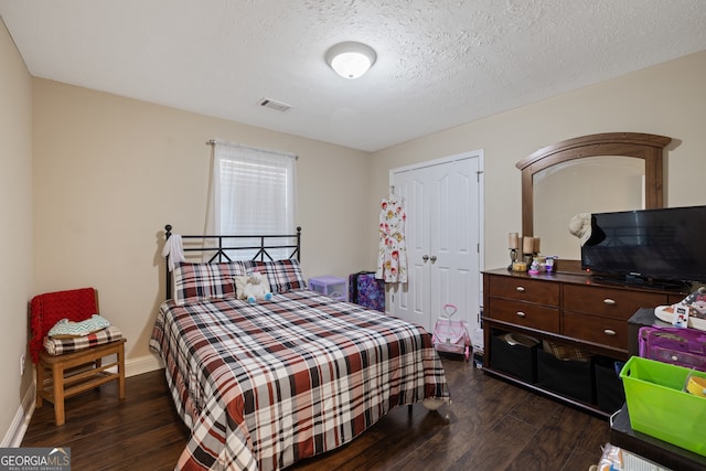 bedroom featuring a textured ceiling, a closet, and dark hardwood / wood-style floors