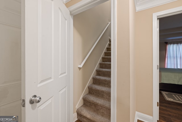 stairs with crown molding and hardwood / wood-style flooring