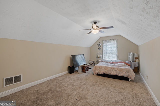 unfurnished bedroom featuring ceiling fan, a textured ceiling, lofted ceiling, and carpet floors