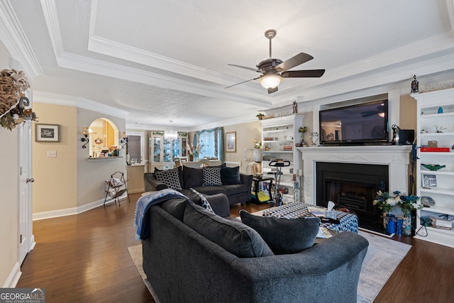 living room with ornamental molding, ceiling fan, and dark hardwood / wood-style floors