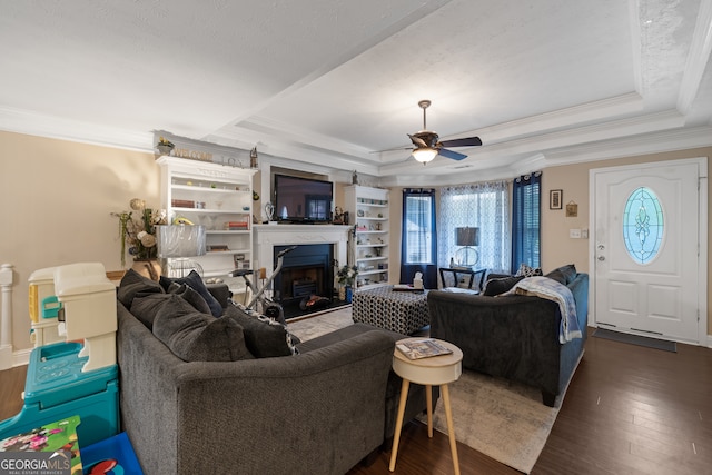 living room featuring ceiling fan, a tray ceiling, crown molding, and dark hardwood / wood-style flooring